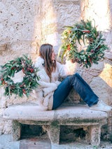Corona de Navidad con frutos rojos y piñas