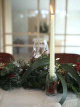 Camino de mesa navideño con frutos rojos y piñas