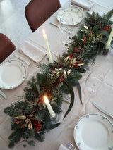 Camino de mesa navideño con frutos rojos y piñas