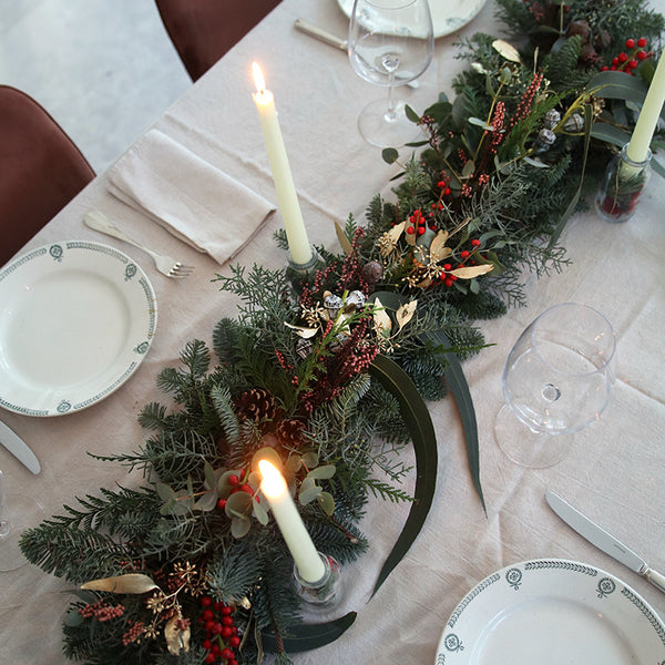 Camino de mesa navideño con frutos rojos y piñas